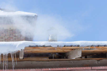 Icicles on vintage roof closeup. Winter weather concept. Froze and ice background. Christmas weather concept. Snow and icicle. Melting icicles. Long sharp icicles. Frozen water. Cold weather conceptの写真素材