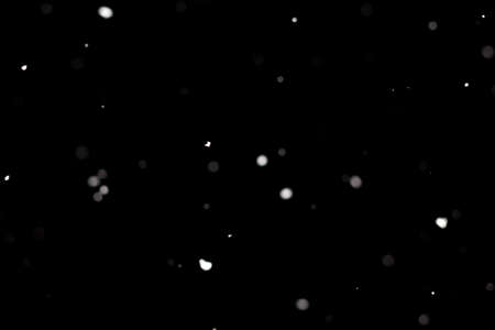 Snowstorm texture. Bokeh lights on black background, shot of flying snowflakes in the airの写真素材