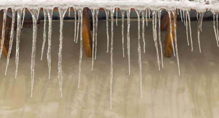Icicles on vintage roof closeup. Winter weather concept. Froze and ice background. Christmas weather concept. Snow and icicle. Melting icicles. Long sharp icicles. Frozen water. Cold weather conceptの写真素材