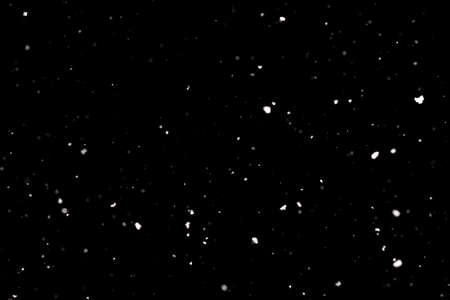 Snowstorm texture. Bokeh lights on black background, shot of flying snowflakes in the airの写真素材
