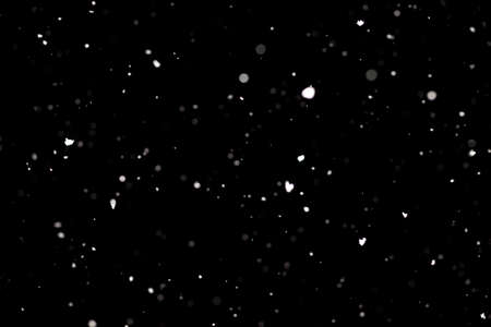 Snowstorm texture. Bokeh lights on black background, shot of flying snowflakes in the airの写真素材