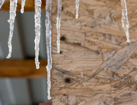 Icicles on vintage roof closeup. Winter weather concept. Froze and ice background. Christmas weather concept. Snow and icicle. Melting icicles. Long sharp icicles. Frozen water. Cold weather conceptの写真素材