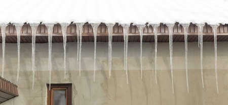 Icicles on vintage roof closeup. Winter weather concept. Froze and ice background. Christmas weather concept. Snow and icicle. Melting icicles. Long sharp icicles. Frozen water. Cold weather conceptの写真素材
