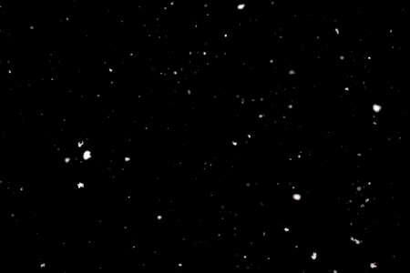 Snowstorm texture. Bokeh lights on black background, shot of flying snowflakes in the airの写真素材