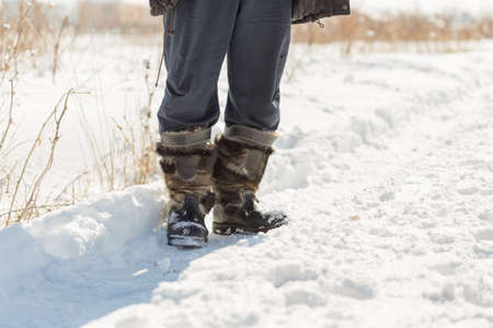 a walk in the snow. closeup of winter shoesの写真素材
