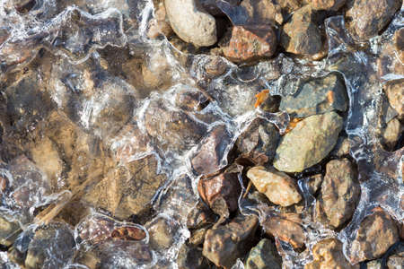 Ice crystals on a stony wet ground on a clear morningの写真素材