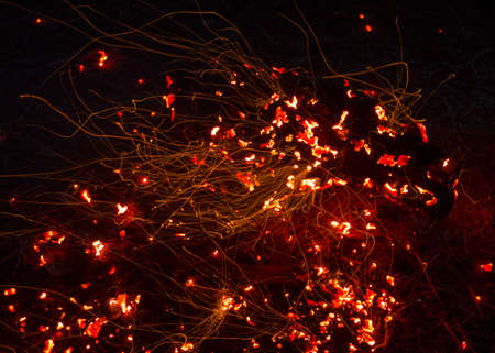 Bright sparkling coals with fire as backgroundの写真素材