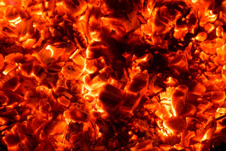 Bright sparkling coals with fire as backgroundの写真素材
