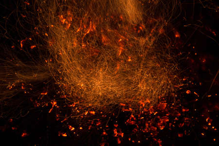 Burning fire in the night. Flame and fire sparkles on a dark abstract background. Hellish element of fire. Fuel, power and energyの写真素材