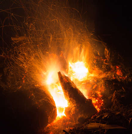 Burning fire in the night. Flame and fire sparkles on a dark abstract background. Hellish element of fire. Fuel, power and energyの写真素材