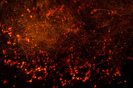 Bright sparkling coals with fire as backgroundの写真素材