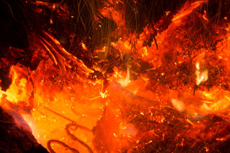 Bright sparkling coals with fire as backgroundの写真素材