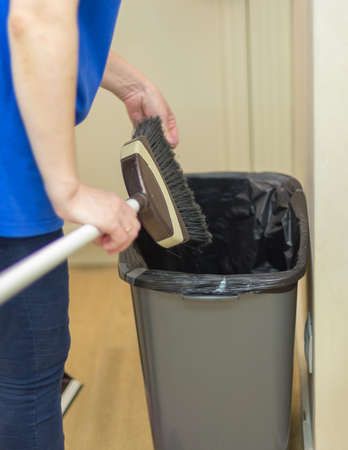 Woman holding a broom. Girls carry a brush with cleaning products. Woman preparing for cleaningの写真素材