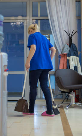 Woman holding a broom. Girls carry a brush with cleaning products. Woman preparing for cleaningの写真素材
