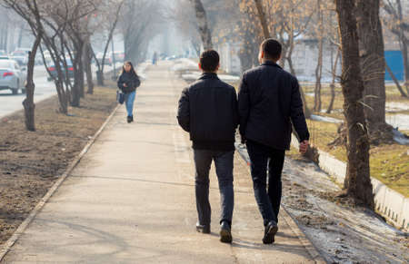 young people on the sidewalk along the roadの写真素材