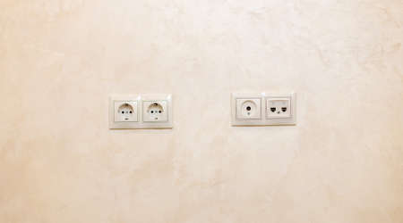 A set of two sockets, a connector for the antenna and a connector for phones mounted on the wallの写真素材