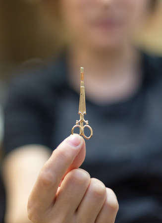 key chain, mini scissors in the hands of manの写真素材