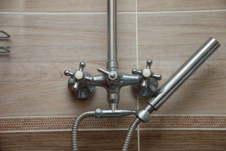 closeup of the faucets of a shower with a shower handの写真素材