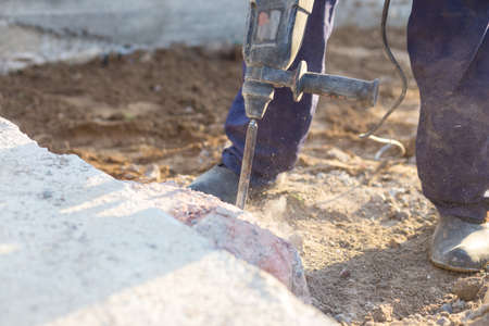 man breaks the concrete with a jackhammer