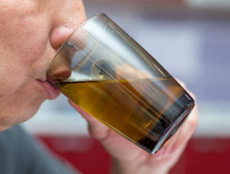 Man drinking tea in a glass cup, cozy atmosphere
