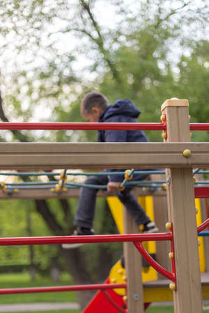 brave boy playing on the playground and going down with ropes downの写真素材