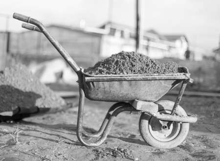 Old one-wheeled car full of stones for constructionの写真素材