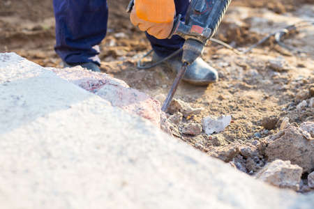 man breaks the concrete with a jackhammerの写真素材