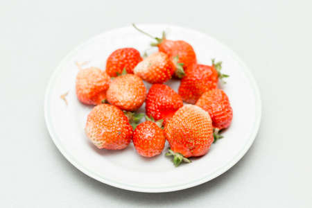 Strawberries on a white background, fresh, tasty and natural strawberries from grandfather's garden on a white plateの写真素材