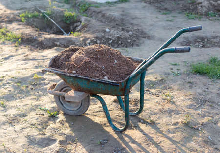 Old one-wheeled car full of stones for constructionの写真素材