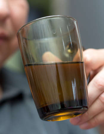Man drinking tea in a glass cup, cozy atmosphere