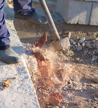 man smashes concrete with heavy sledgehammerの写真素材
