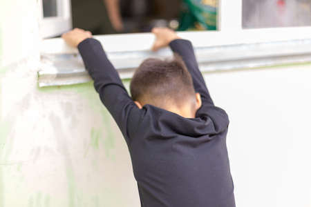 children crawl out the window from the street wants to get homeの写真素材