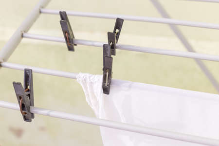 A rack dryer stands outside on a sunny day to dry white clothes. Foldable clothes dryer.の写真素材
