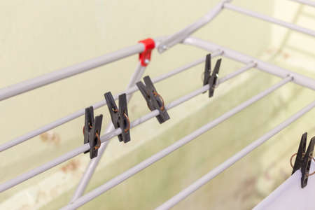 A rack dryer stands outside on a sunny day to dry white clothes. Foldable clothes dryer.の写真素材