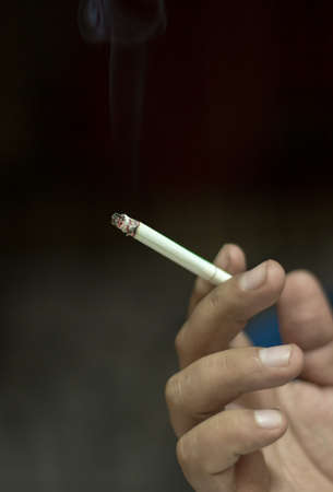 holding cigarettes on a black backgroundの写真素材