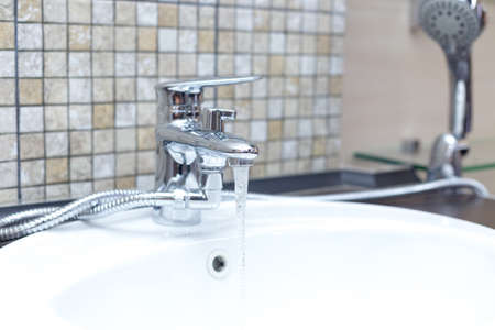 wooden countertop in a modern bathroom white porcelain sink with showerの写真素材
