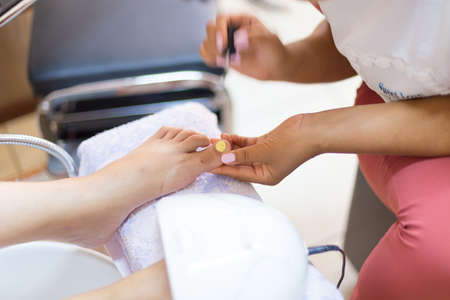 Woman legs gets a pedicure. Close up concept.の写真素材