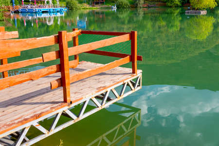 Autumn paradise. Wooden ladder for fishing in the river. Green water in the lakeの写真素材