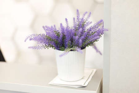 artificial blue flower in a plastic pot on the tableの写真素材