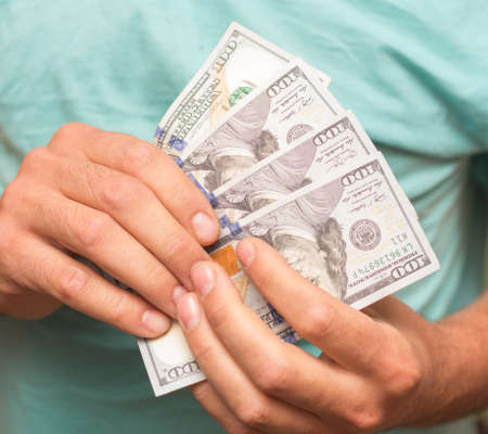 Man's hands holding hundred dollar bills. Business conceptの写真素材