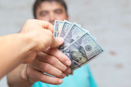Man's hands holding hundred dollar bills. Business concept