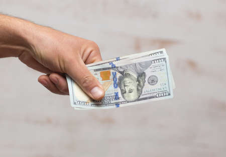 Man's hands holding hundred dollar bills. Business conceptの写真素材