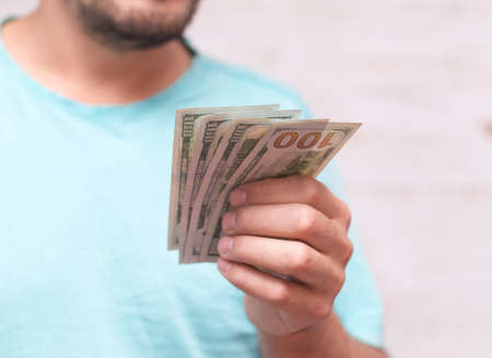 Man's hands holding hundred dollar bills. Business concept