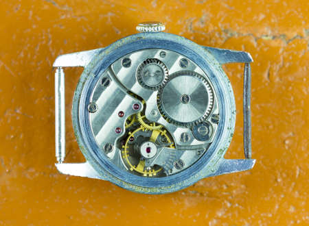 inside a mechanical clock on a table, yellow backgroundの写真素材
