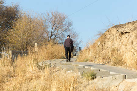 a gray-haired old man climbs the stairs. Senior healthy lifestyle.の写真素材