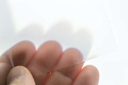 transparent white film close-up in a manâs handの写真素材