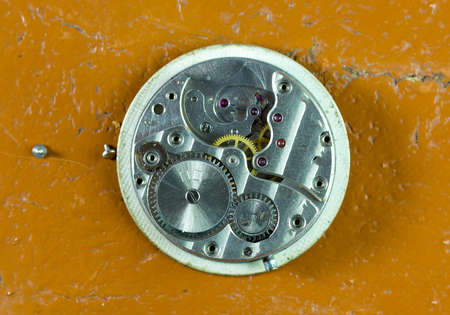 inside a mechanical clock on a table, yellow backgroundの写真素材