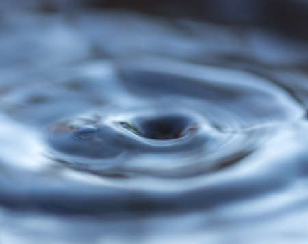 Drops from the tap fall into a bucket of water. Tap water.の写真素材