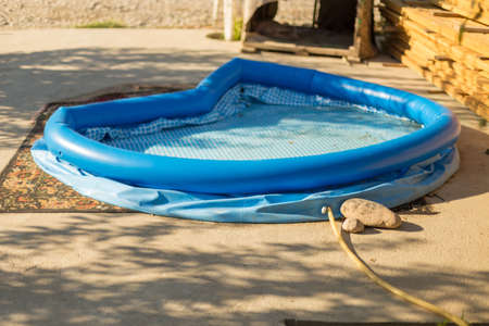 Blue inflatable rubber pool in the courtyard of a country houseの写真素材
