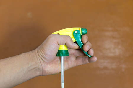 yellow water spray in hand.の写真素材